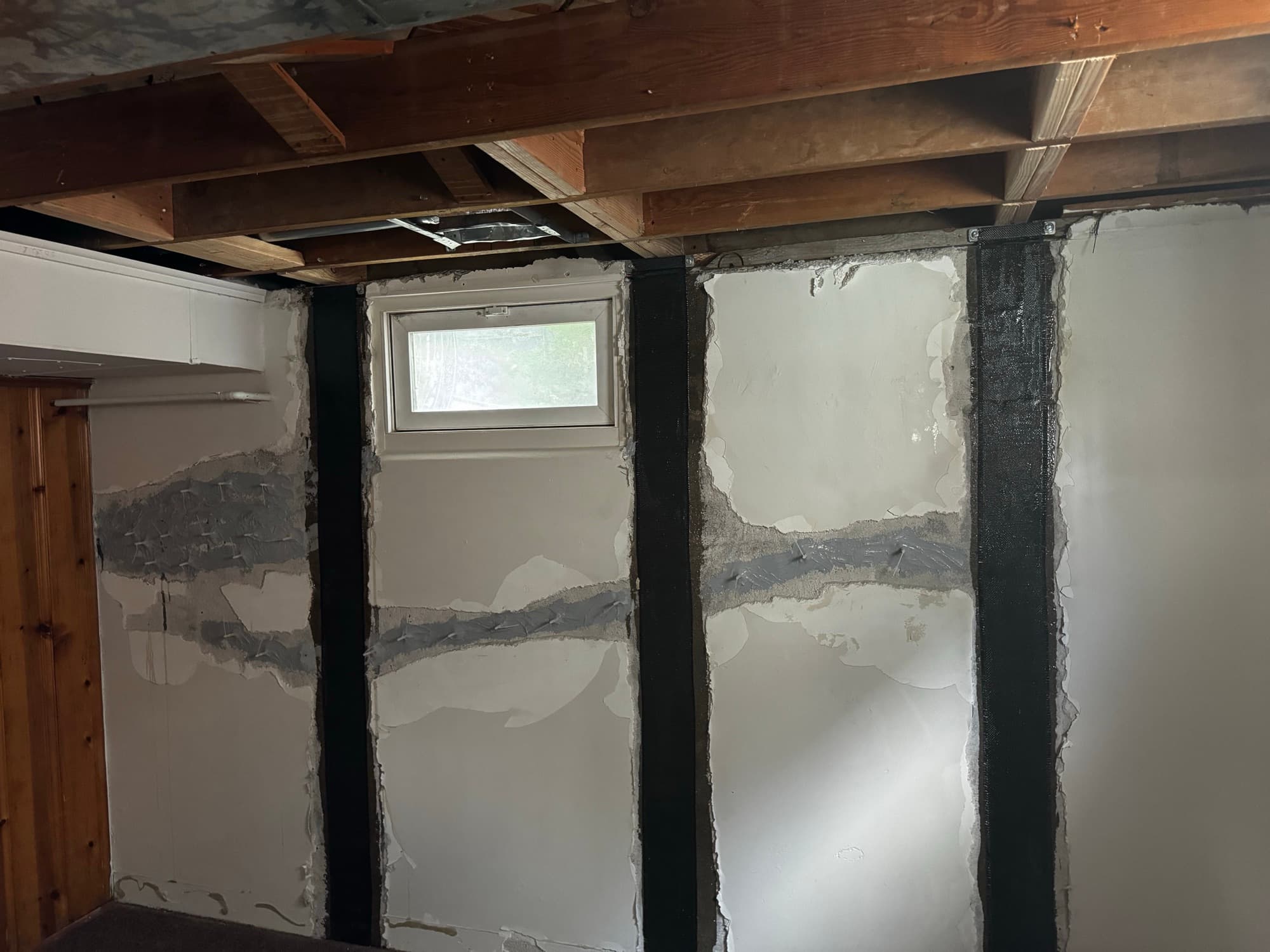 Carbon fiber straps on a cracked basement wall, cracks sealed with epoxy
