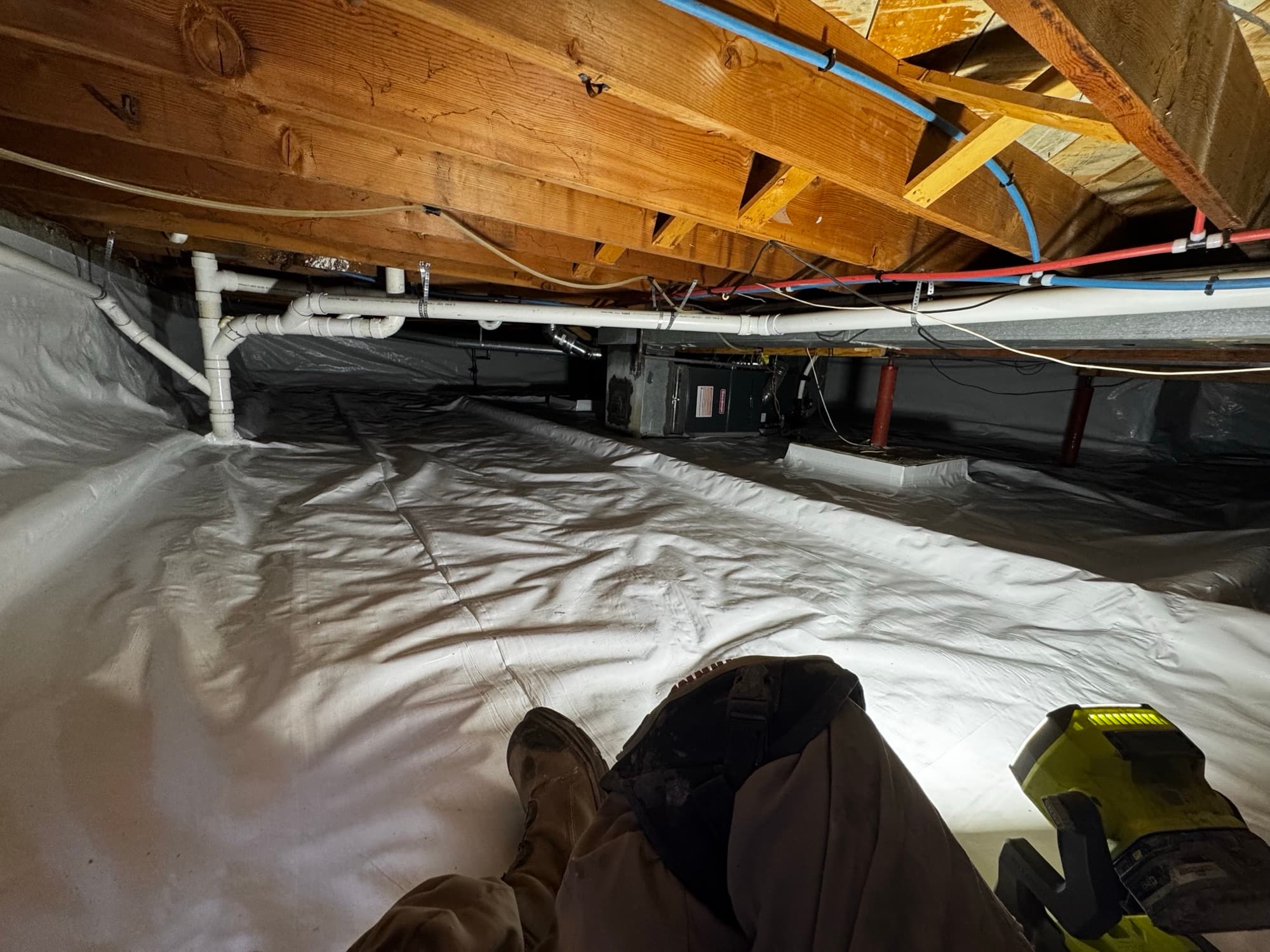 Crawl space covered wall to wall in white vapor barrier