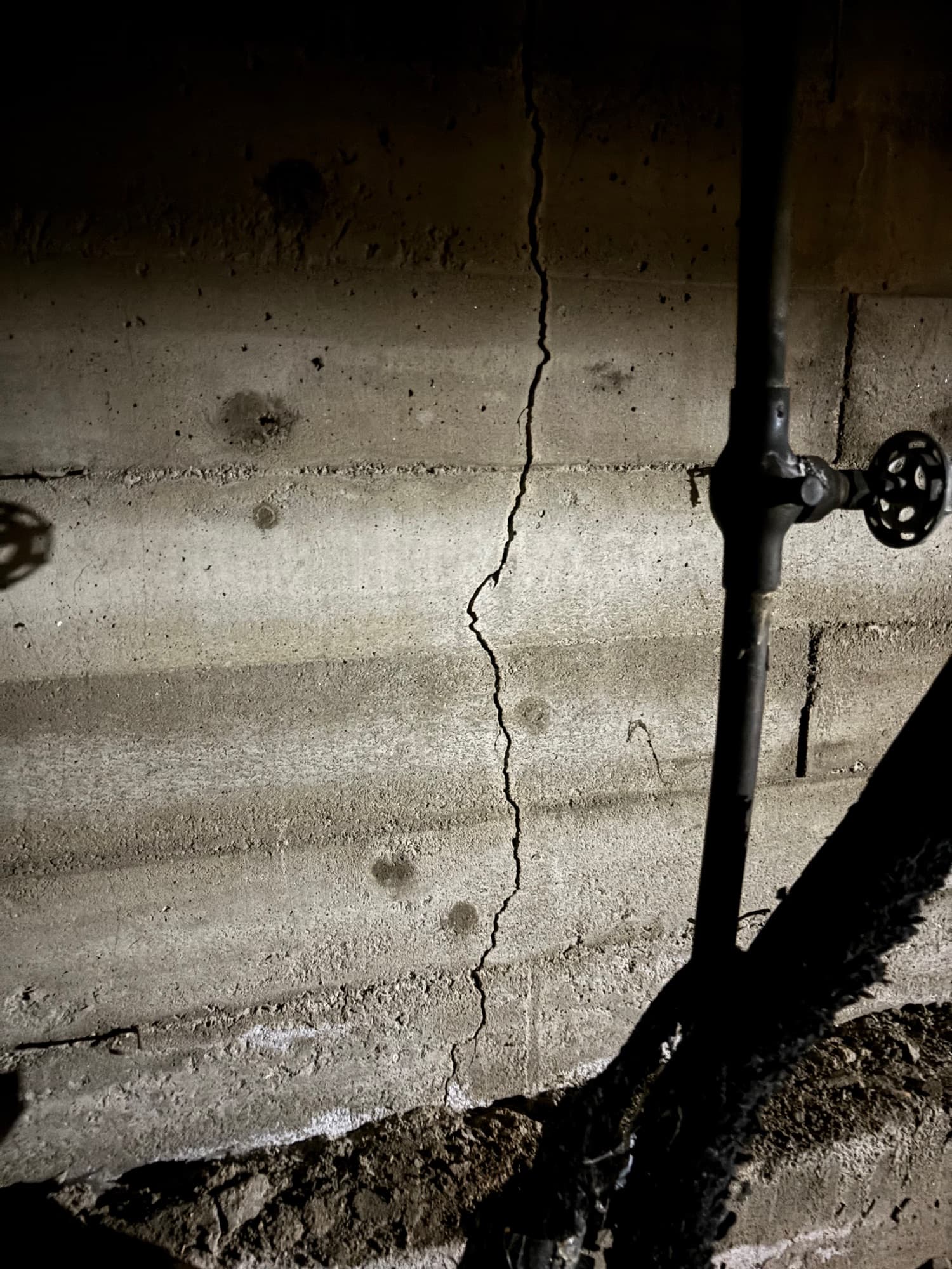 Vertical crack running down a concrete foundation wall